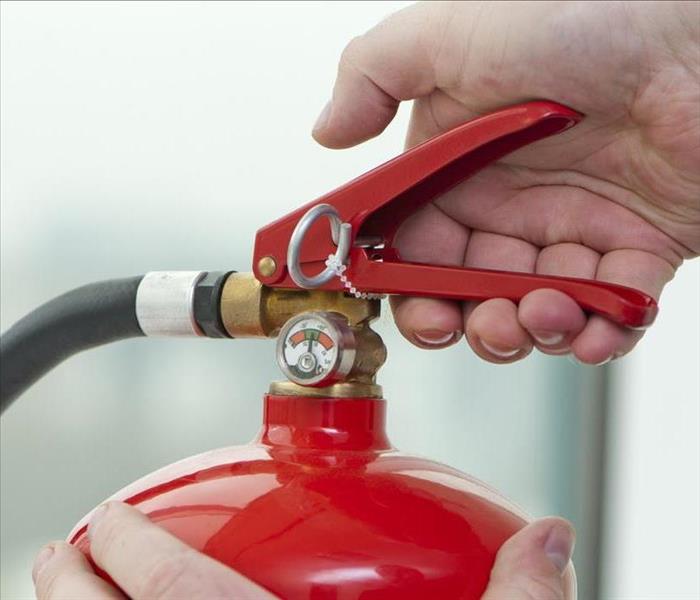 Image of person holding a fire extinguisher