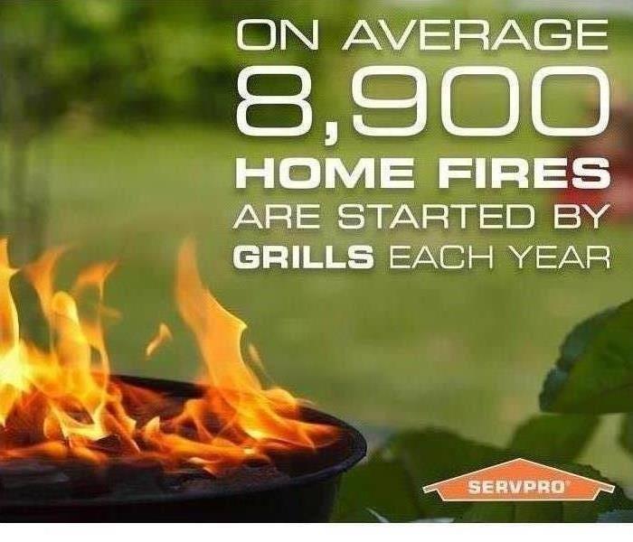 black grill with flames coming out of it and the orange servpro branded house