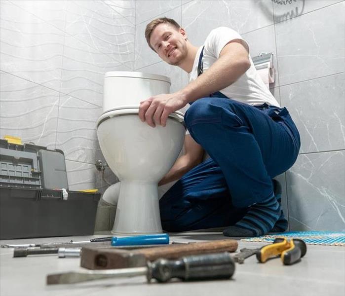 Professional repairing a Leaky Toilet.